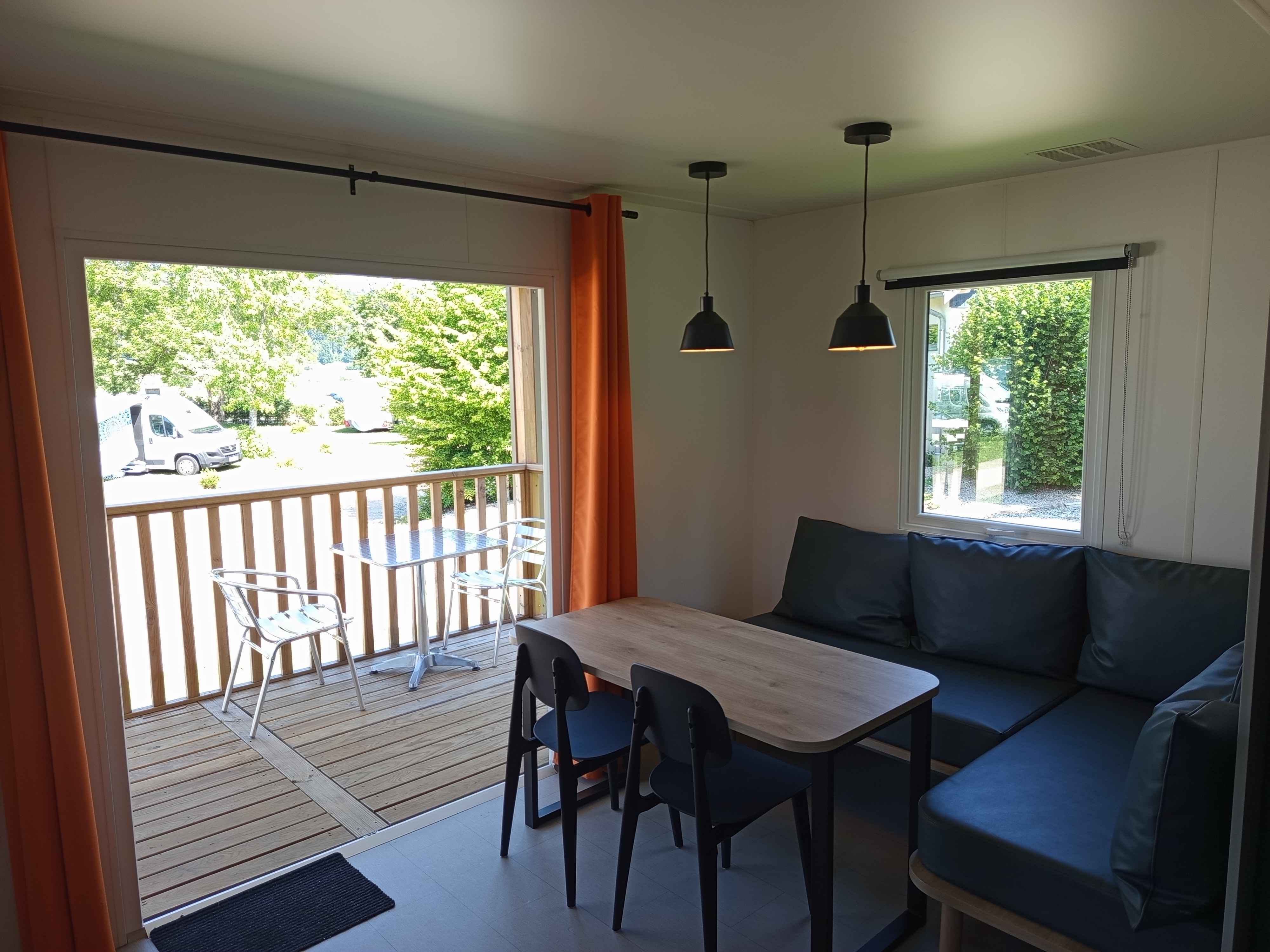 Le salon et la baie vitrée La terasse du mobil-home avec ses équipements